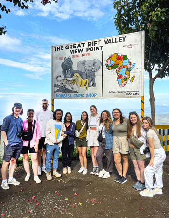 Group of travellers standing at a viewpoint of the Great Rift Valley in the Maasai Mara, Kenya