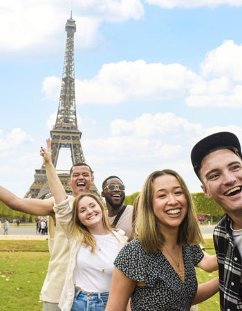 Travellers posing in front of the Eiffel Tower in Paris, France